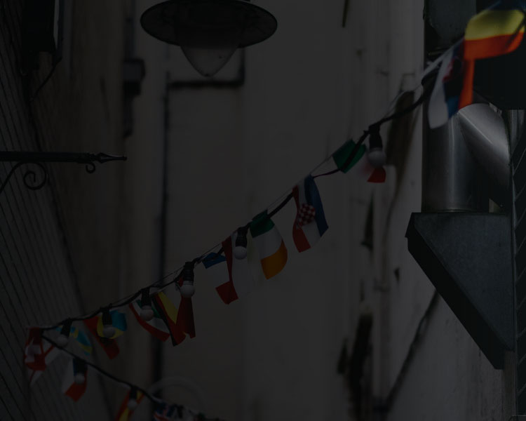 different international flags hanging between buildings