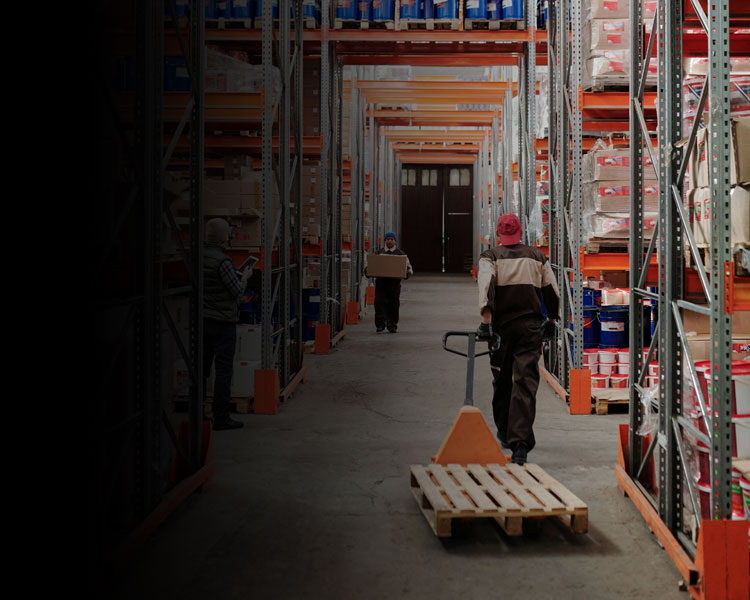 Man pulling pallet truck in warehouse